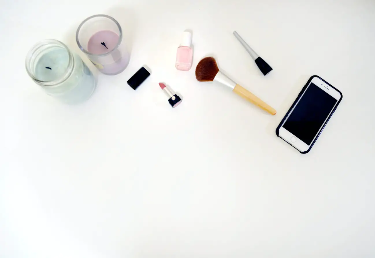 Picture of minimalist makeup and candles on a white surface