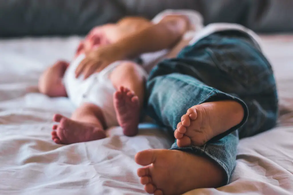 Toddler and baby on a bed