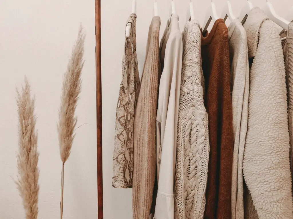 Tan and brown clothing on a wood clothes rack