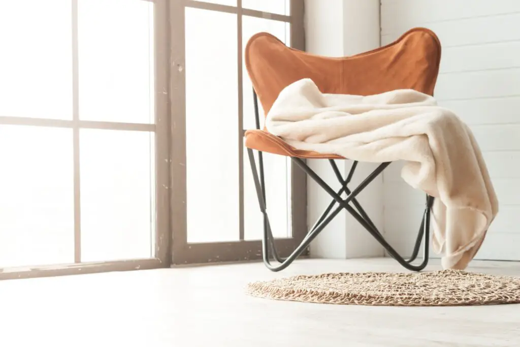 leather chair and cozy blanket- how to create a cozy minimalist home