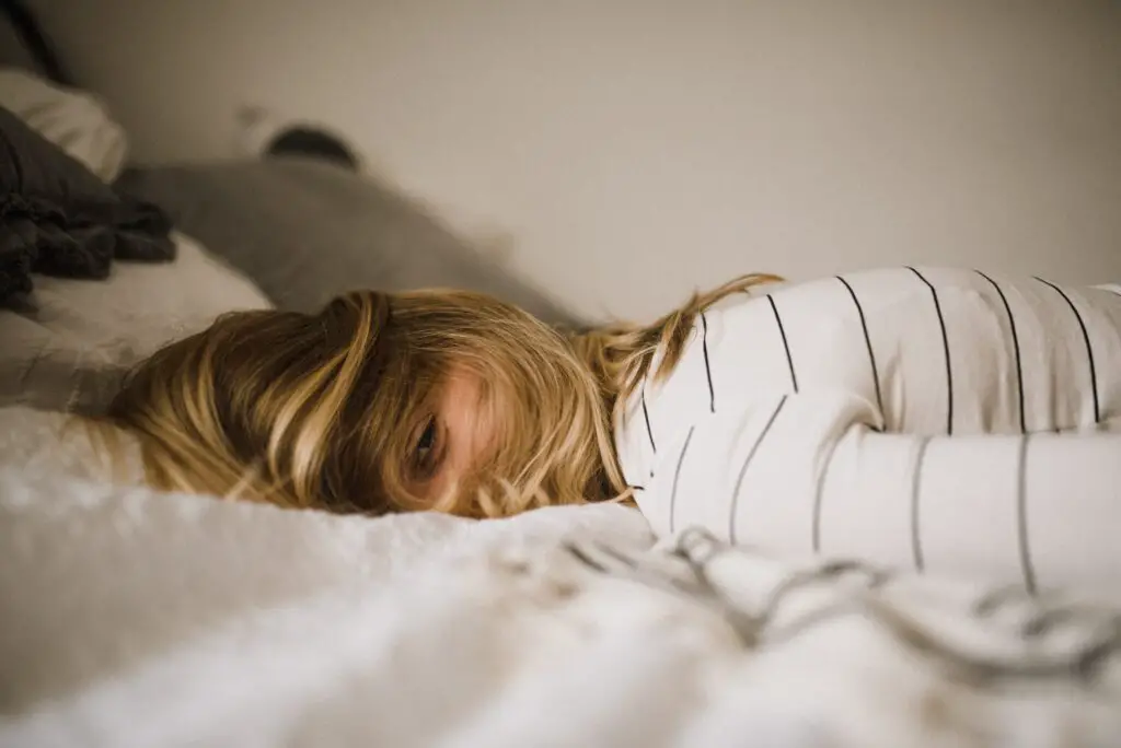 Woman lying down on bed dealing with a midlife crisis